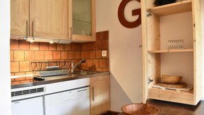 A kitchen with wooden cabinets, a Siemens dishwasher, a tiled backsplash, and a wooden bowl on the counter. - 100m from ski slopes, 3rd floor, balcony, tv, 28m², Méribel (Méribel - Les Allues)