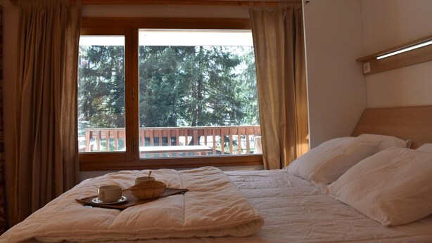 A bedroom with a bed, a window with curtains, and a view of a balcony. - 150m from shops, Ground floor, terrace, ski locker, 40m², Méribel (Méribel - Les Allues)