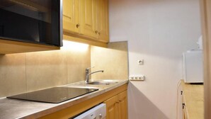 A compact kitchen with a sink, dishwasher, and a microwave.