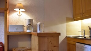 A compact kitchen with a coffee maker, kettle, and a lamp on a shelf. - 200m from shops, 1st floor, view mountain, balcony, ski locker, 28m², Méribel (Méribel - Les Allues)