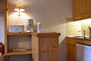 A compact kitchen with a coffee maker, kettle, and a lamp on a shelf. - 200m from shops, 1st floor, view mountain, balcony, ski locker, 28m², Méribel (Méribel - Les Allues)