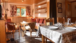 A cozy dining area with a wooden table set for four, surrounded by wicker chairs. - 150m from ski slopes, 1st floor, balcony, tv, ski locker, 70m², Méribel (Méribel - Les Allues)
