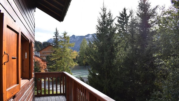 A wooden balcony with a view of a river, mountains, and trees. - 150m from ski slopes, 1st floor, balcony, tv, ski locker, 70m², Méribel (Méribel - Les Allues)