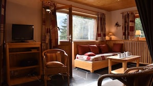A cozy room with a bed, a chair, a table, and a television. - 150m from ski slopes, 1st floor, balcony, tv, ski locker, 70m², Méribel (Méribel - Les Allues)