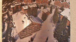 Et skiområde med flere chalet-lignende bygninger, en skilift og et sneklædt landskab.
