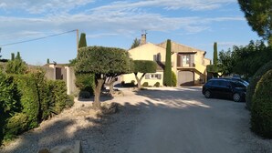 A residential driveway leading to a house with a car parked in the driveway. - Mas Dansavan (Oppede)
