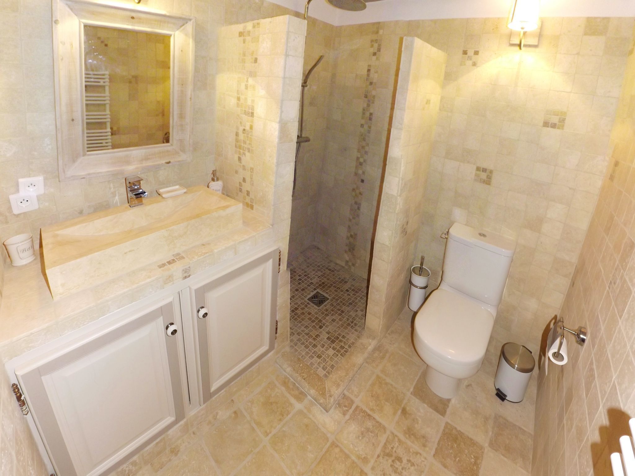 A bathroom with a shower, toilet, and sink.