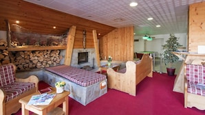 A cozy room with a fireplace, wooden furniture, and a red carpet. - Ski-in/ski-out & foot of the slopes, swimming pool, balcony, tv, 40-45m², Orcières Merlette 1850 (Orcières)