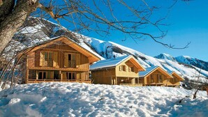 A wooden chalet with a balcony, surrounded by snow-covered mountains. - Wifi, swimming pool, terrace, parking, tv, ski locker, 42m², Saint Sorlin d'Arves (Saint-Sorlin-d'Arves)