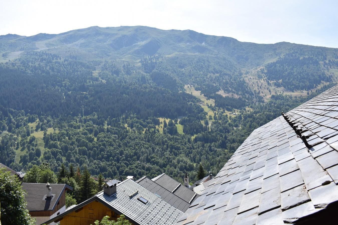 A mountain view from a building with a sloped roof.