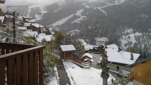 A snow-covered mountain village with traditional wooden houses, a wooden deck, and a view of the valley. - 300m from shops, 2nd floor, balcony, ski locker, 40m², Méribel (Méribel - Les Allues)