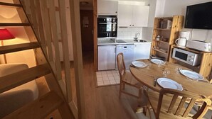A compact kitchen with white cabinets, a microwave, and a built-in oven. - 300m from shops, 2nd floor, balcony, ski locker, 40m², Méribel (Méribel - Les Allues)