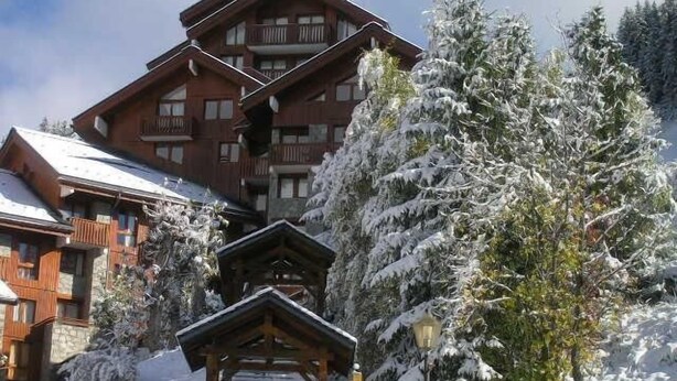 A wooden lodge with a balcony, surrounded by snow-covered trees. - 300m from shops, 2nd floor, balcony, ski locker, 40m², Méribel (Méribel - Les Allues)