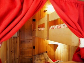 A wooden bunk bed room with a ladder and a red curtain. - 4th floor, balcony, tv, ski locker, 26m², Les Menuires (Les Menuires)