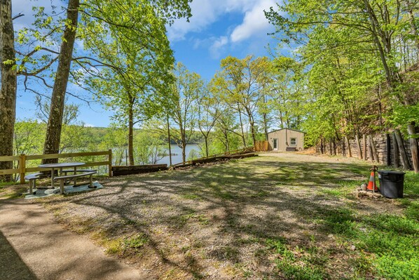 A picnic area with benches and a small cabin by a lake. - Eagles Rest on Kentucky Lake- peaceful spot for vacation overlooking the lake (Waverly)