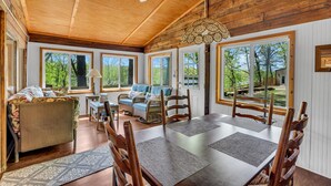 Una habitación amplia con una gran mesa de comedor, sillas de madera, un sofá y un ventilador de techo.