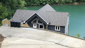 A house with a steep driveway, a garage, and a view of a lake.