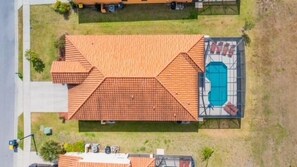 Vista aérea de un edificio con un techo plano grande y una piscina a la derecha.