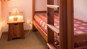 A bunk bed room with a desk and lamp, a window with curtains, and a carpeted floor. - 1st floor, balcony, tv, ski locker, 40m², Aussois (Aussois)