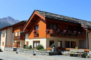 A traditional chalet with wooden balconies, stone steps, and a mountain backdrop. - 1st floor, balcony, tv, ski locker, 41m², Aussois (Aussois)