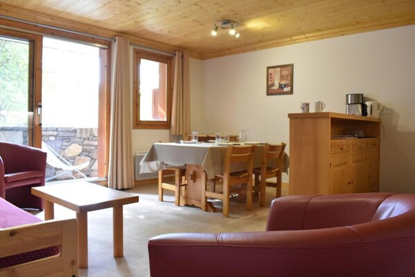 A cozy room with a dining table, wooden chairs, a sofa, and a cabinet. - 250m from shops, 3rd floor, tv, ski locker, 41m², Méribel (Méribel - Les Allues)
