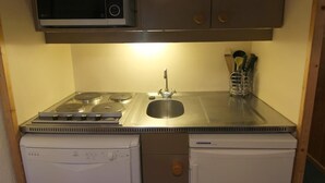A compact kitchen with a microwave, stove, sink, and dishwasher. - 200m from resort center, 4th floor, balcony, 28m², Val Thorens (Val Thorens)