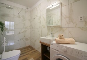 Regadera, secadora de cabello, toallas, papel de baño 