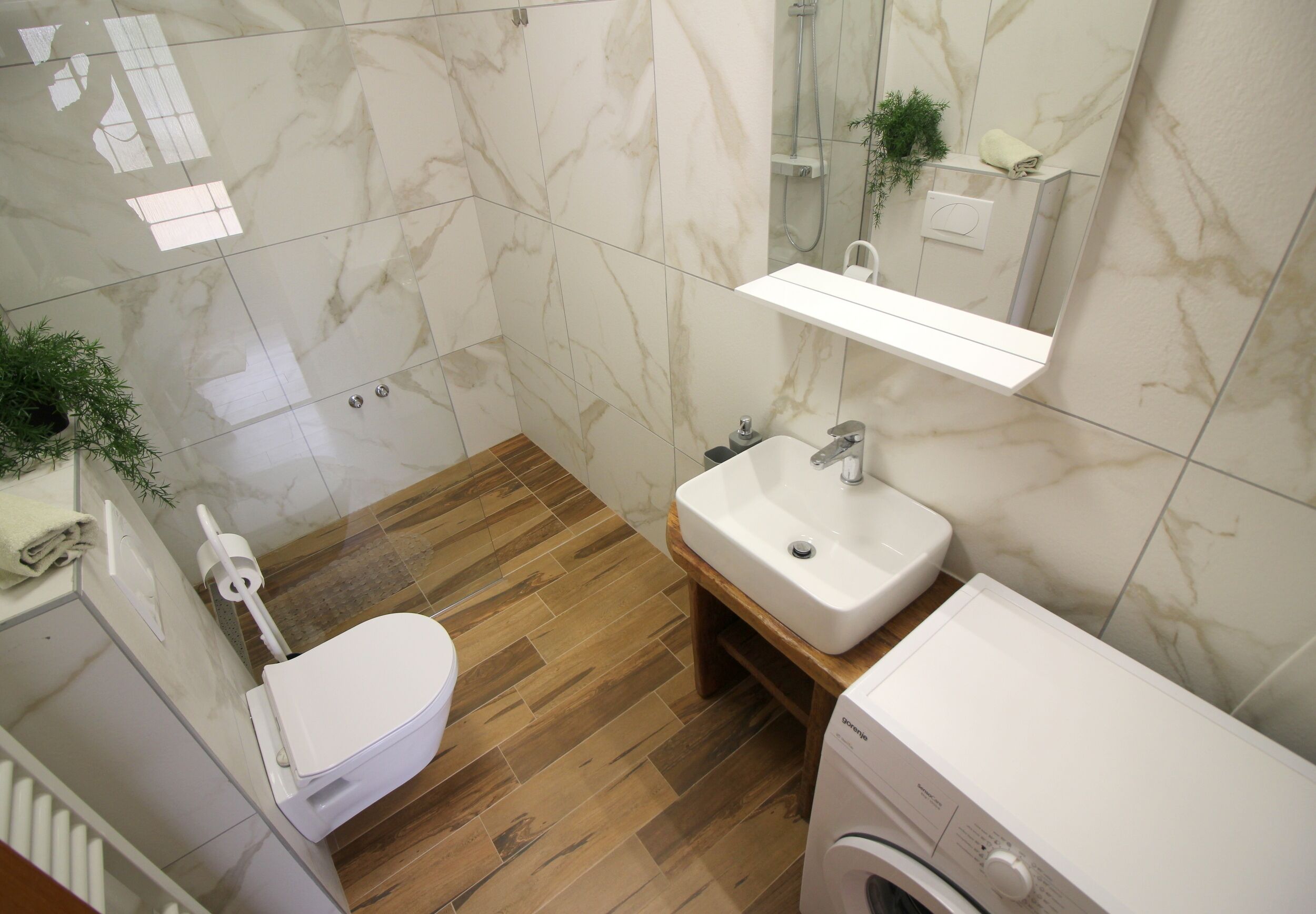 A bathroom with a toilet, sink, and washing machine.