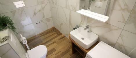 A bathroom with a toilet, sink, and washing machine.