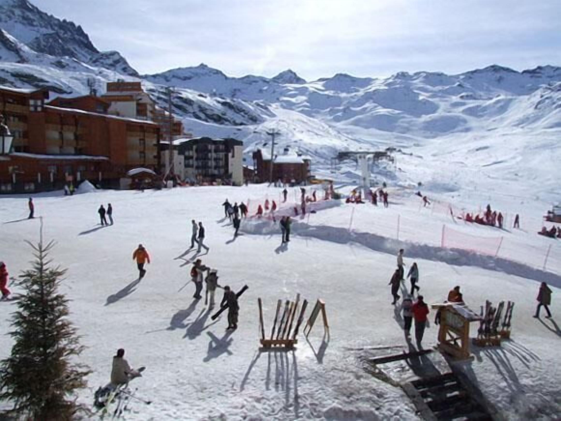 A ski resort with snow-covered slopes, buildings, and a ski lift.