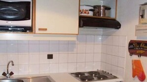 A compact kitchen with a microwave, stove, sink, and a small refrigerator. - 10m from resort center, 2nd floor, tv, 30m², Val Thorens (Val Thorens)