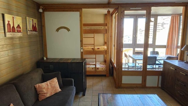 Ein gemütliches Zimmer mit Etagenbett, einer Schlafcouch und einem Esstisch.