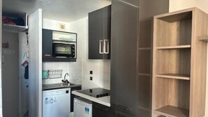 Une cuisine compacte équipée d’un four à micro-ondes, d’un évier et d’un petit réfrigérateur.
