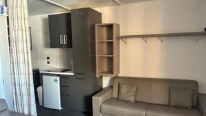 A compact living space with a kitchenette, a sofa, and a small table. - 50m from ski slopes, 4th floor, balcony, tv, 30m², Val Thorens (Val Thorens)