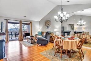 A spacious living room with a dining area, large windows, and a fireplace. - Give Your Family a New "Pointe of View" at this 2 bed condo at Pointe Royale! (Branson)
