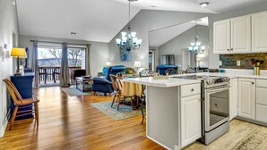 A spacious kitchen with white cabinets, a large island, and a built-in oven. - Give Your Family a New "Pointe of View" at this 2 bed condo at Pointe Royale! (Branson)