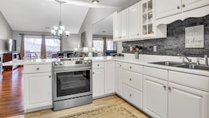 A modern kitchen with white cabinetry, a stainless steel oven, and a granite countertop. - Give Your Family a New "Pointe of View" at this 2 bed condo at Pointe Royale! (Branson)