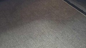 Un letto a castello con una scrivania e un comò, pareti in legno e pavimento rivestito di moquette.