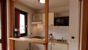 A compact kitchen with a coffee maker, a microwave, and a sink. - 50m from ski slopes, 6th floor, balcony, tv, 35m², Val Thorens (Val Thorens)