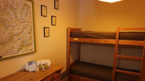 A bunk bed room with a wooden desk, a map on the wall, and a small table with toiletries. - 50m from ski slopes, 6th floor, balcony, tv, 35m², Val Thorens (Val Thorens)