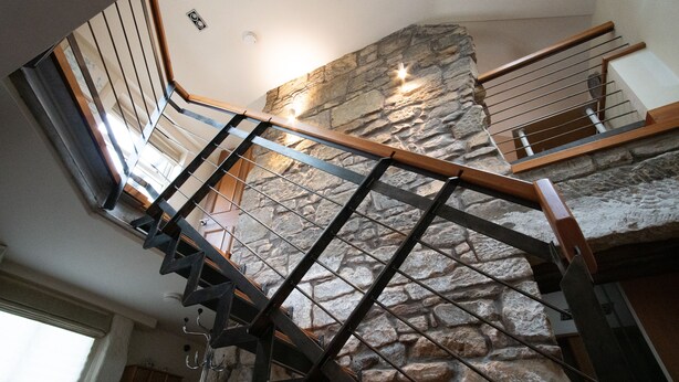 A staircase with a stone wall backdrop and wooden handrails. - Characterful Semi-Detached House; Enviably Located (St Andrews)