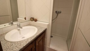 Ein Badezimmer mit Waschbecken, Spiegel und Dusche.