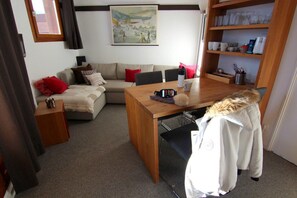 Relax in this inviting living area with a comfortable sofa, wooden coffee table, and a cozy atmosphere.