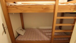 Un lit superposé avec une couverture à carreaux et un oreiller.
