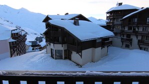 A snow-covered building with a balcony and a mountain backdrop. - 150m from ski slopes, floor -1, balcony, 29m², Val Thorens (Val Thorens)