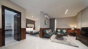 Ein modernes Hotelzimmer mit Bett, einer Couch, einem Couchtisch und einem Fernseher.