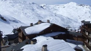 A snow-covered mountain village with traditional wooden buildings and a clear view of the surrounding peaks. - 150m from ski slopes, 3rd floor, view ski slopes, balcony, 29m², Val Thorens (Val Thorens)