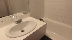 A bathroom with a white sink, a mirror, and a bathtub. - 150m from ski slopes, 3rd floor, view ski slopes, balcony, 29m², Val Thorens (Val Thorens)