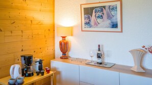 A kitchen with a coffee maker, cups, a wine bottle, and glasses on the counter. - 200m from ski slopes, 1st floor, balcony, tv, 37m², Val Thorens (Val Thorens)