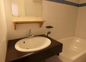 A bathroom with a white sink, a mirror above it, and a bathtub.